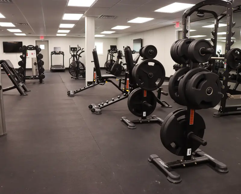 Fitness room with plate racks, adjustable benches, strength machines and cardio equipment