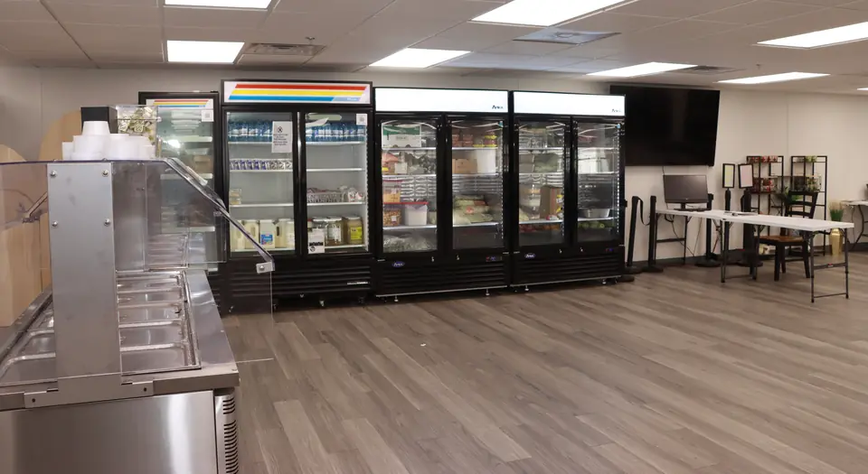 Glass-door coolers stocked with food and drinks in a dining hall