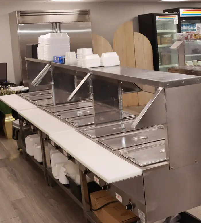 Stainless-steel serving line with heated food wells and a refrigerated salad bar